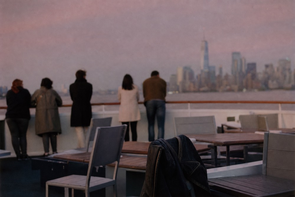Passengers on a dinner cruise deck with the Eiffel Tower in the distance at dusk, no text, no logos, no people