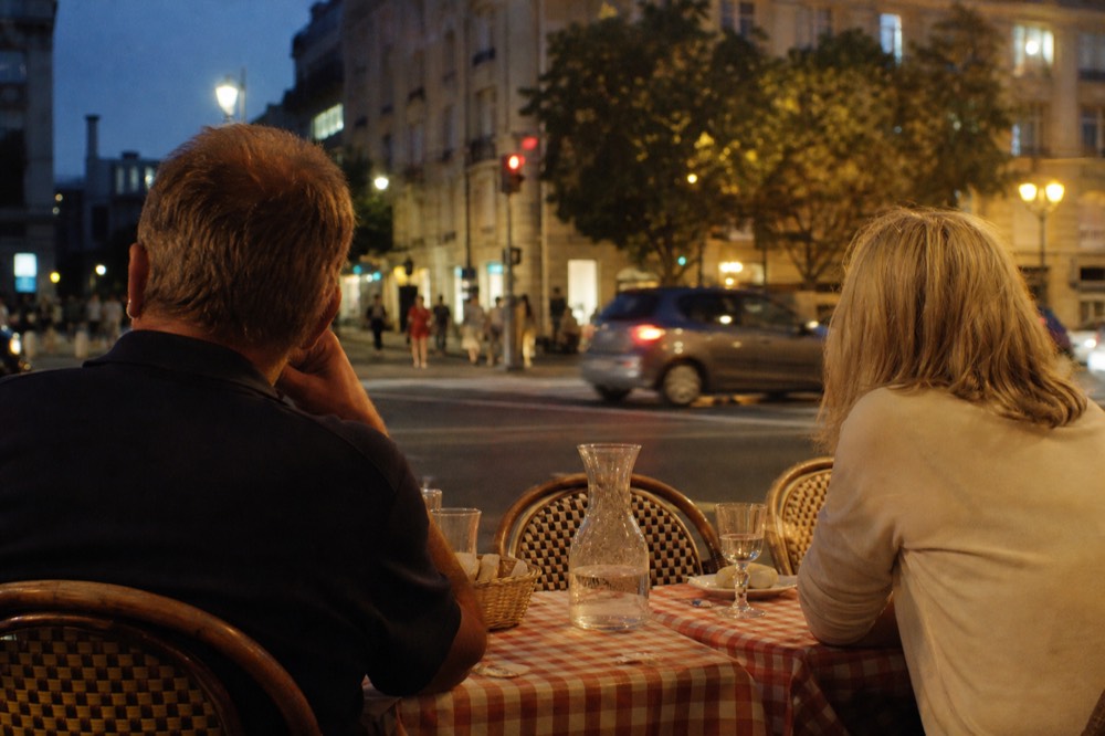 Diners seated at a Paris bistro table in the evening, no text, no logos, no people