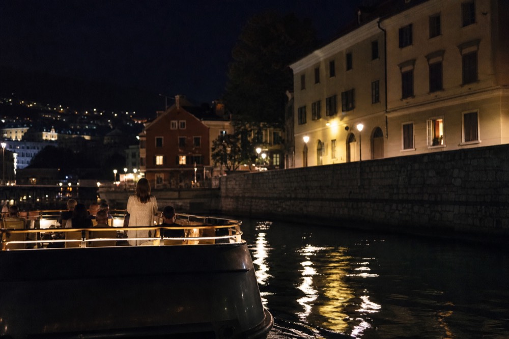 Seine dinner cruise boat gliding past illuminated Parisian architecture at night, no text, no logos, no people