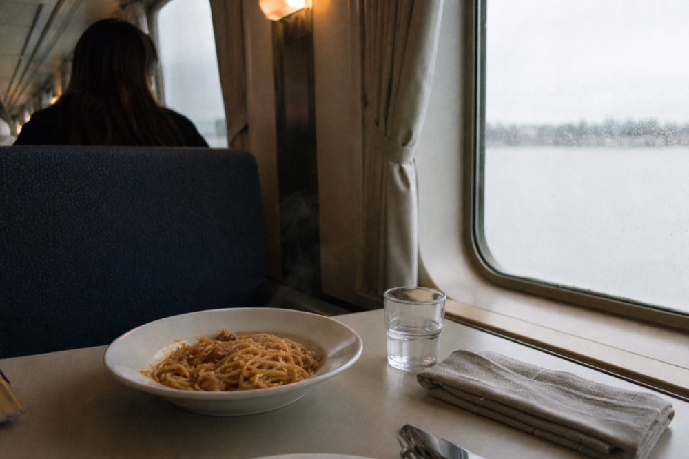 A plated pasta dinner served at a table aboard a Seine dinner cruise, no text, no logos, no people